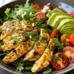 Nahaufnahme eines Hähnchen-Salats mit frischem Gemüse und Avocado.