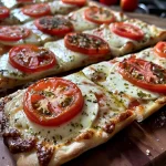 Leckerer Tomate-Mozzarella-Flammkuchen mit Pesto, in Nahaufnahme.