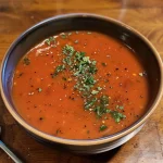 Nahaufnahme einer köstlichen Tomatensuppe aus dem Thermomix in einer Schüssel.