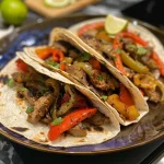 Saftige Hähnchen-Fajitas mit buntem Gemüse auf einem Teller.