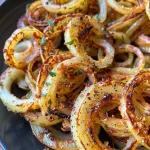 Nahaufnahme von Spiralkartoffel-Spießen, die in einer Fritteuse zubereitet werden.