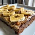 Saftige Bananen-Proteinpfannkuchen auf einem Teller, im Vordergrund aufgenommen.