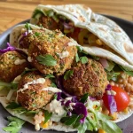 Nahaufnahme eines Falafel-Wraps mit frischen Zutaten.