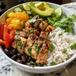 Nahaufnahme eines Honey Lime Chicken Burrito Bowls mit frischen Zutaten.