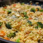 Nahaufnahme von One Pot Orzo Pasta mit Gemüse und Käse.
