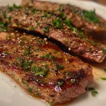 Nahaufnahme von Rindfleisch mit Paprika und Zwiebeln auf einem Teller.