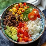 Nahaufnahme eines cremigen Taco-Reis-Bowls mit Rinderhack in einer Schüssel.