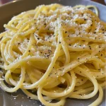 Nahaufnahme von cremiger Zitronen-Sahne-Pasta mit frischen Kräutern.