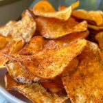 Nahaufnahme von knusprigen Süßkartoffel-Chips auf einem Teller.