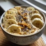 Nahaufnahme einer cremigen Smoothie-Schüssel mit Bananen und Erdnussbutter.