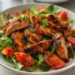 ['Close-up view of a vibrant BBQ chicken salad with colorful vegetables.', 'Juicy BBQ chicken slices atop a fresh salad of greens and various veggies.', 'Side view of delicious BBQ chicken salad featuring tomatoes, cucumbers, and peppers.', 'Appetizing BBQ chicken salad with greens, chicken, and diced vegetables.']