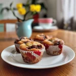 ['A close-up side view of a chocolate and pear muffin, showcasing its marbled texture.', 'Juicy Birnen Marmor Muffins displayed, highlighting the rich chocolate and pear blend.', 'Side view of a moist muffin with a mix of chocolate and pear, featuring a glossy finish.', 'Detailed shot of freshly baked marble muffins with pear pieces and chocolate swirls.']