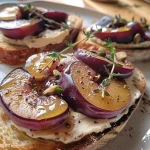 ['Close-up of creamy cheese toast topped with roast plums and pistachio dukkah.', 'Side view of a delicious cheese toast garnished with sliced purple plums and nuts.', 'Juicy cheese toast featuring roasted plum wedges and a sprinkle of dukkah.', 'Detailed view of a slice of sourdough topped with cream cheese, plums, and pistachios.']