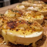 ['Close-up view of baked Hokkaido pumpkin topped with cheese and honey.', 'Side angle of roasted Hokkaido pumpkin garnished with feta cheese and seeds.', 'Juicy Hokkaido pumpkin dessert with a drizzle of honey and crumbled cheese.', 'Baked Hokkaido pumpkin served with herbs and honey in a cozy kitchen setting.']