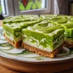 ['Side view of a slice of Grüner Hokkaido Cheesecake with a smooth green pumpkin filling.', 'Close-up of a creamy slice of Grüner Hokkaido Cheesecake showcasing its rich texture.', 'A decadent slice of Grüner Hokkaido Cheesecake on a plate, highlighting its colorful layers.', 'Detailed image of a slice of Grüner Hokkaido Cheesecake, featuring a buttery crust and vibrant filling.']