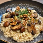 ['A close-up view of creamy risotto featuring mushrooms and walnuts, garnished with fresh herbs.', 'Side view of a delicious bowl of mushroom and walnut risotto, with melted Taleggio cheese visible.', 'A vibrant dish of Risotto ai Funghi Misti, highlighting the texture of the rice and toppings.', 'Juicy mushroom and walnut risotto served in a rustic bowl, showcasing its creamy consistency.']