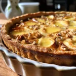 ['Close-up view of a walnut pie showcasing its golden crust and walnut halves on top.', 'Side view of a juicy walnut pie highlighting its rich filling and flaky crust.', 'Detailed photograph of a walnut pie with a shiny surface and visible walnut pieces.', 'Side shot of a freshly baked walnut pie with a smooth and glossy appearance.']