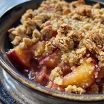 ['Close-up of a juicy sugar-free plum crumble with a golden crust and fresh plums.', 'Side view of a delicious sugar-free plum crumble featuring a crumbly topping.', 'Tasty zuckerfreier Pflaumen Crumble on a plate, highlighting the layers of plums and nuts.', 'Appetizing image of sugar-free plum crumble showcasing the baked oat and nut topping.']