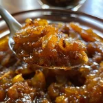 ['Close-up view of a jar of Birnen Chutney with visible chunks of pears and spices.', 'A side view of a jar filled with rich, dark-colored Birnen Chutney displaying pear pieces.', 'Detailed image of Birnen Chutney with a glistening texture, showcasing ingredients like chili and cinnamon.', 'Side perspective of homemade Birnen Chutney, highlighting spices and fruit in a glass jar.']