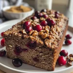 ['Close-up side view of a freshly baked cranberry walnut bread showcasing its textured crust and vibrant cranberries.', 'Detailed side shot of cranberry walnut bread with visible chunks of cranberries and walnuts, highlighting its golden crust.', 'A side perspective of a loaf of cranberry walnut bread, emphasizing the juicy cranberries and chopped walnuts in the dough.', 'Richly textured cranberry walnut bread displayed from the side, showing its moist interior and crunchy exterior.']