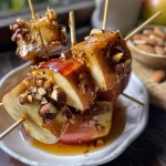 ['Close-up view of healthy caramel apple skewers with diced apples and toppings.', 'Side view of skewered caramel apples garnished with nuts and chocolate chips.', 'Juicy apple cubes on skewers drizzled with almond butter and toppings.', 'Delicious caramel apple bites arranged on a wooden skewer with various toppings.']