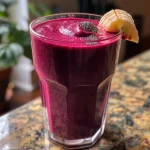 ['Close-up of a vibrant beet and carrot smoothie in a glass, showcasing its deep red color.', 'Side view of a healthy smoothie made from beets and carrots, with a thick texture and colorful presentation.', 'Glass filled with a nutritious beet carrot smoothie, garnished with chia seeds, set against a light background.', 'Refreshing beet and carrot smoothie displayed in a clear glass, highlighting its fresh ingredients.']