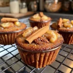 ['A side view of golden-brown spiced quince muffins with a textured top.', 'Close-up of freshly baked quince muffins, showcasing their fluffy interior and spiced crust.', 'Juicy, baked quince muffins displaying a warm color and a crumbly surface.', 'A detailed side shot of spiced quince muffins on a rustic wooden table.']