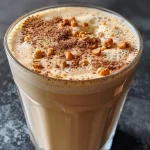 ['A close-up side view of a smooth hazelnut latte in a white cup.', 'A creamy hazelnut latte topped with foam, captured from the side.', 'Detailed view of a hazelnut latte with latte art in a glass cup.', 'A rich hazelnut latte with espresso and milk, shown from the side.']