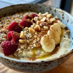 ['Close-up of creamy porridge topped with grape compote in a bowl.', 'Side view of porridge with glistening grape compote and sliced almonds.', 'A bowl of oatmeal garnished with fresh grapes and honey drizzle.', 'Textured porridge with a rich grape sauce, almonds, and a sprinkle of cinnamon.']
