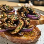 ['Close-up of high-protein vegan toasts topped with mushrooms and caramelized onions.', 'Side view of vibrant and colorful toast with visible mushrooms and herbs.', 'Juicy vegan toast featuring golden caramelized onions and a sprinkle of parsley.', 'Deliciously arranged butter bean and mushroom toast garnished with chili flakes.']