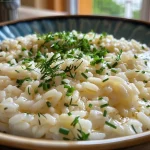 ['Close-up view of sweet risotto with mixed green and red grapes.', 'Side shot of creamy risotto garnished with vibrant grapes.', 'Appetizing bowl of sweet risotto featuring juicy grapes.', 'Detail shot of a delicious risotto dish with grapes.']