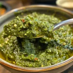 ['Close-up view of a vibrant, creamy vegan pumpkin pesto in a bowl, garnished with fresh herbs.', 'Side angle of a luscious vegan pumpkin pesto spread on a slice of bread, showcasing its rich texture.', 'Bowl of vegan pumpkin pesto with visible pumpkin seeds and herbs, highlighted by natural lighting.', 'Juicy vegan pumpkin pesto displayed with fresh ingredients like pumpkin, garlic, and herbs around it.']