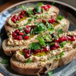 ['A close-up side view of a winter sandwich with caramelized Brussels sprouts.', 'Detailed view of toasted bread topped with hummus and Brussels sprouts.', 'Side shot of a winter sandwich featuring roasted Brussels sprouts and garnishes.', 'Close-up of a gourmet sandwich with Brussels sprouts and a drizzle of balsamic.']